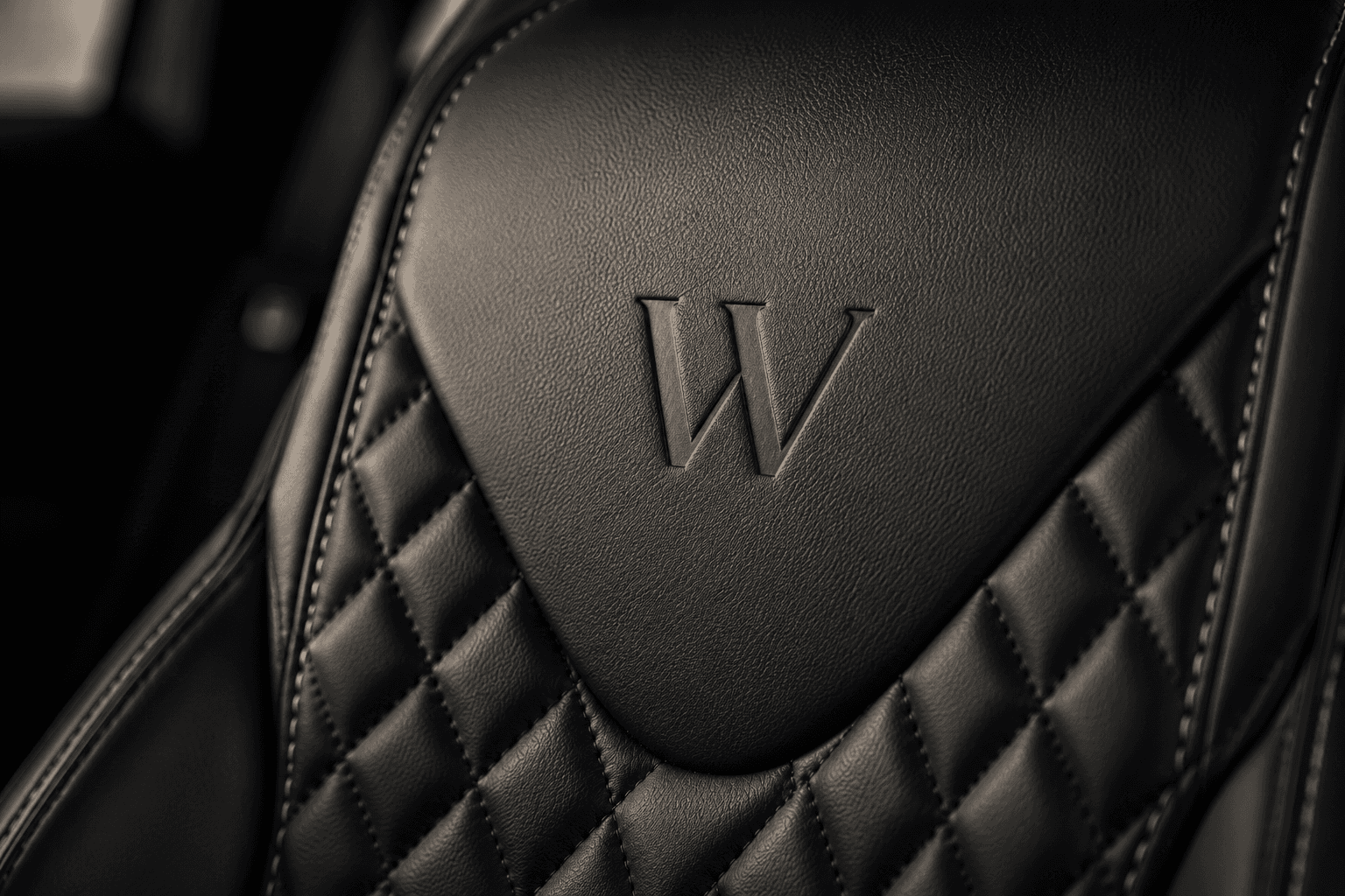 Close-up of quilted leather upholstery embossed with the Weycross W monogram